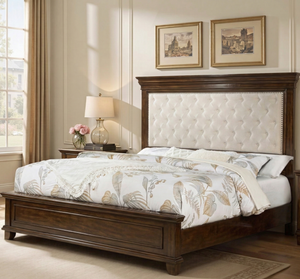 Bedroom with wooden bed frame, floral bedding, and framed artwork on the wall.