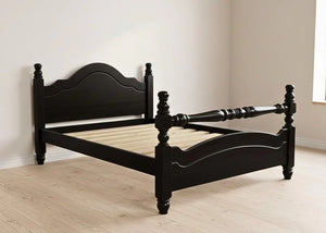 Black wooden bed frame in a room with light wood flooring and white walls.