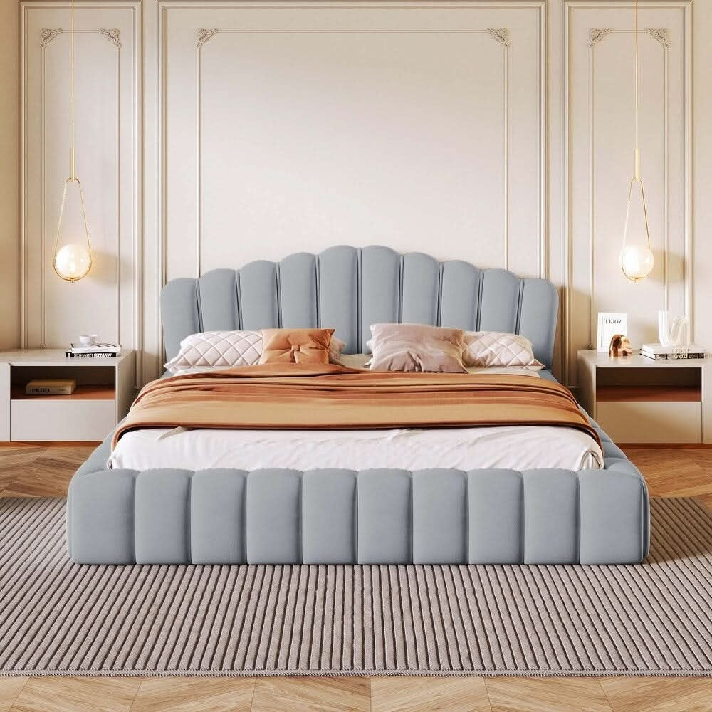 Gray upholstered bed with decorative pillows and a striped blanket in a bedroom setting.