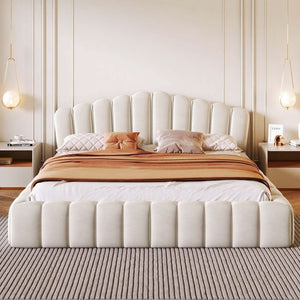 White upholstered bed with brown blanket and pillows in a bedroom setting.