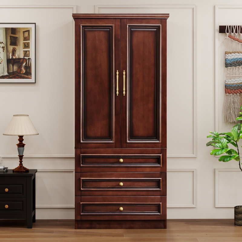 Wooden wardrobe with gold handles in a room setting with a lamp and wall art.